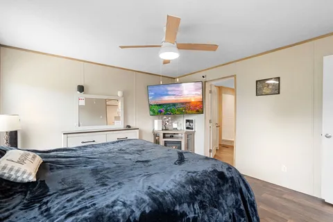 a bedroom with a bed window and a flat screen tv