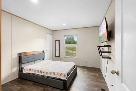 a bedroom with a bed mirror and window