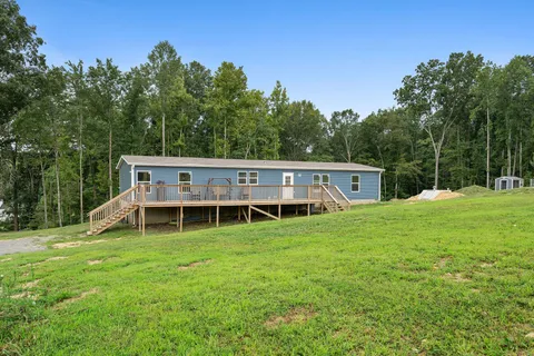 a view of a house with a yard and sitting area