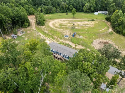 a view of a tennis ground with large trees