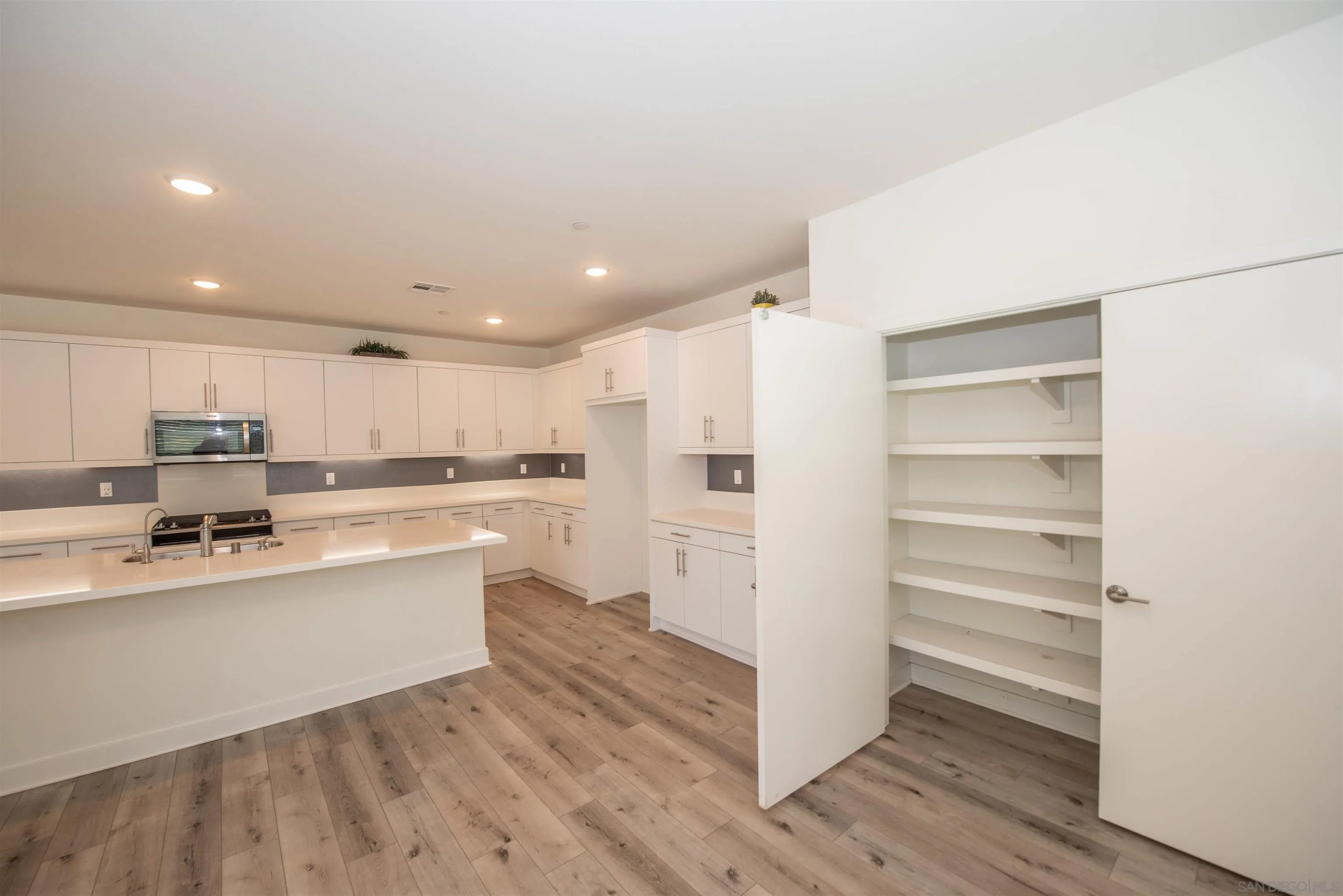 8902 Trailridge Avenue Santee, CA 92071 - Photo 5 of 38 a kitchen with a refrigerator and white cabinets
