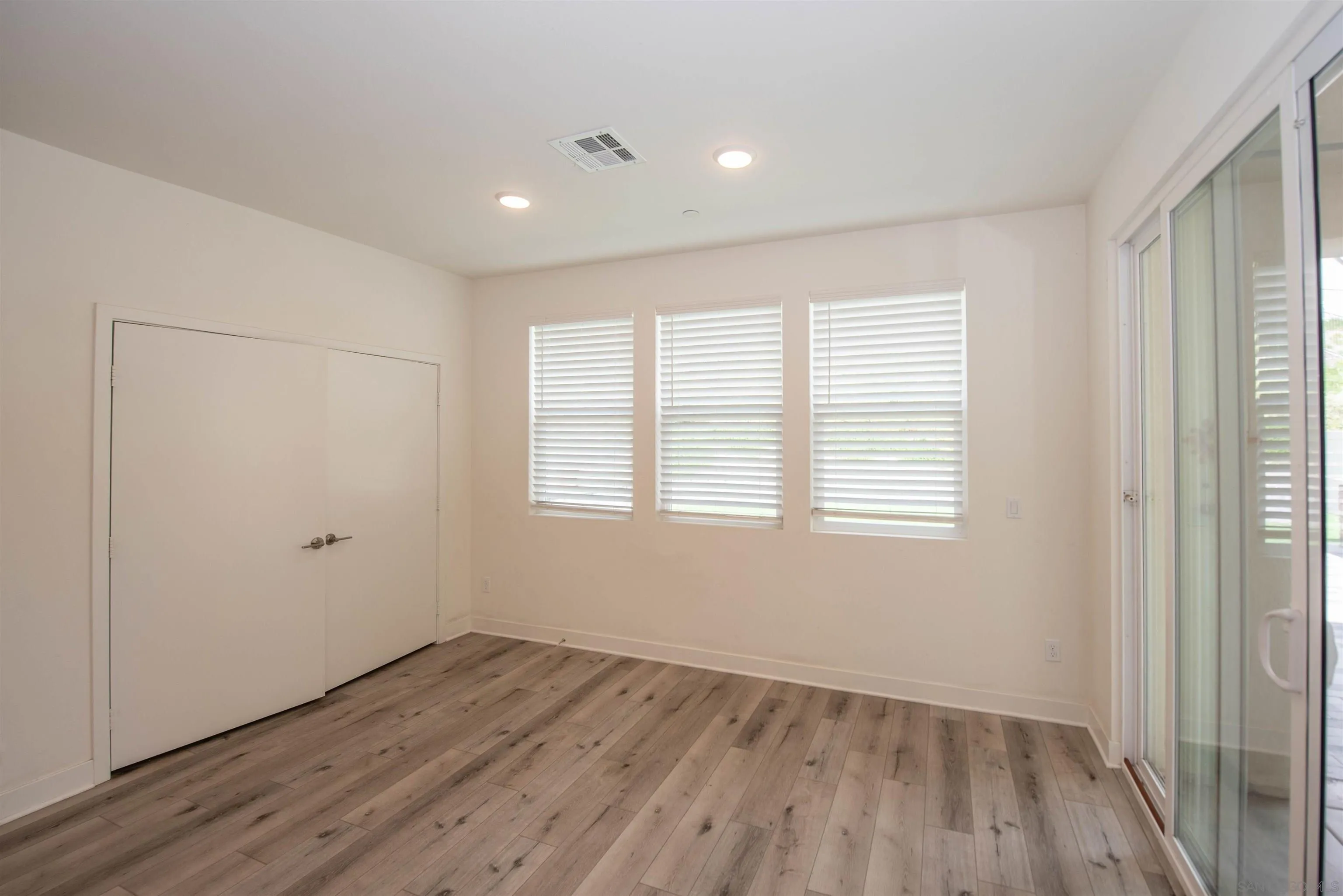 8902 Trailridge Avenue Santee, CA 92071 - Photo 6 of 38 a view of an empty room with wooden floor and a window