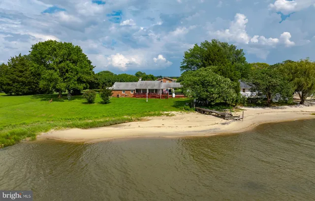 an aerial view of a house with pool and a yard