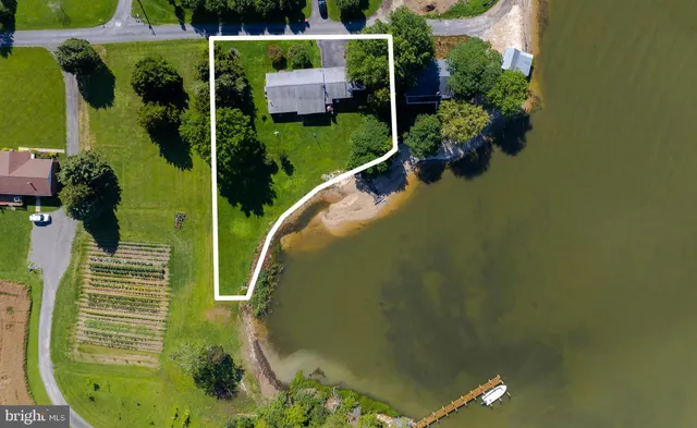 an aerial view of a house with a garden and lake view