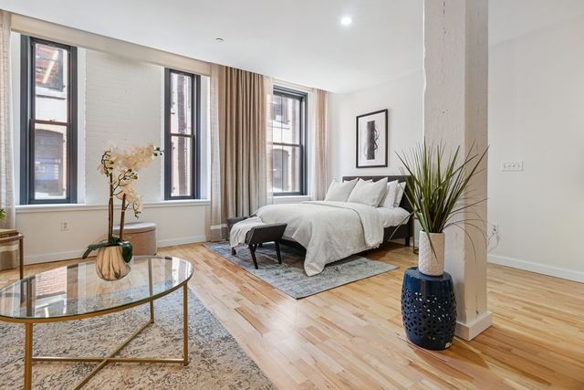 a bedroom with a bed a mirror and a window