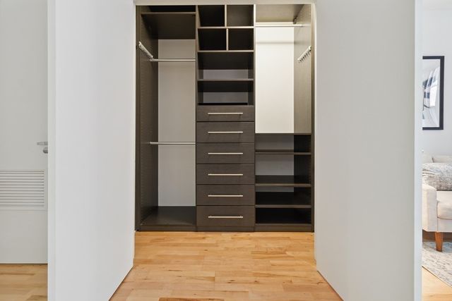 a view of walk in closet with empty racks