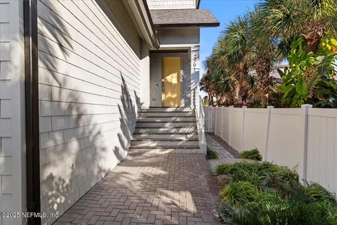 a view of a pathway of a house with backyard and wooden fence