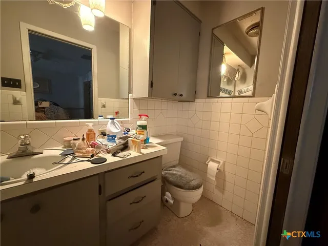 a bathroom with a toilet sink and mirror