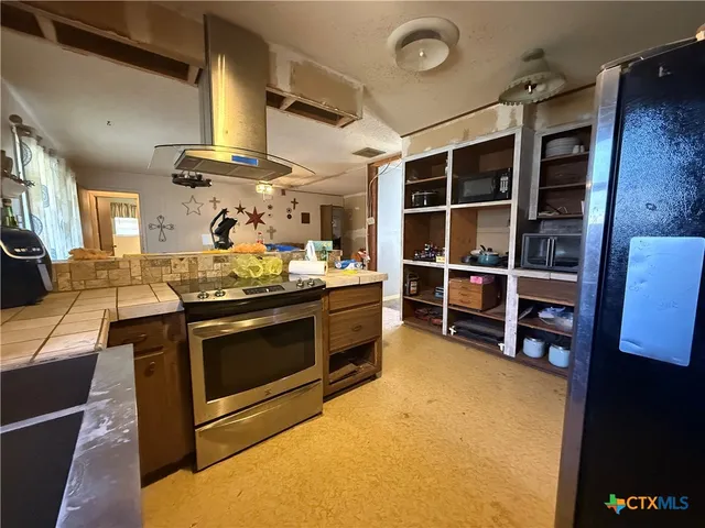 a kitchen with stainless steel appliances granite countertop a stove and a cabinet