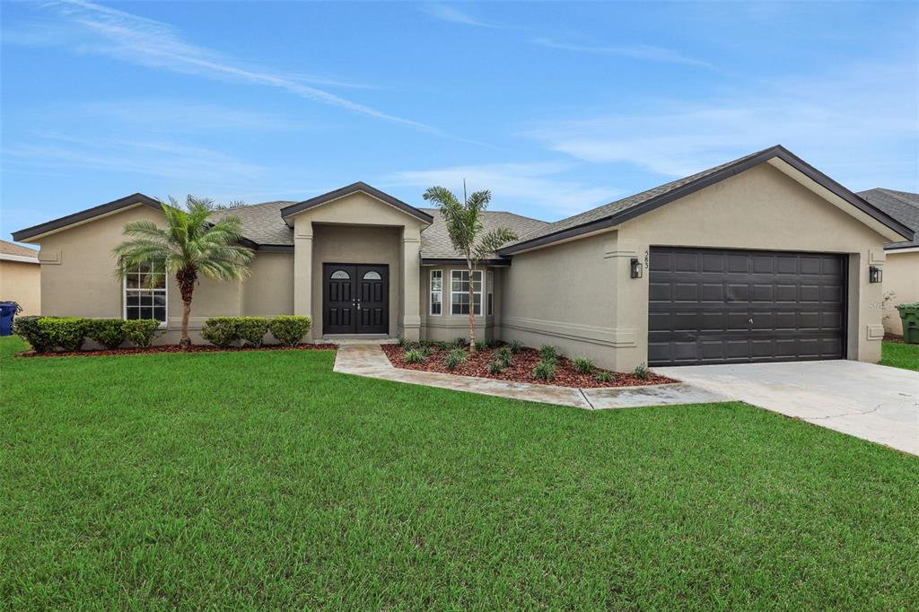 583 Drayton Road Winter Haven, FL 33884 - Photo 1 of 1 a front view of a house with a yard and garage