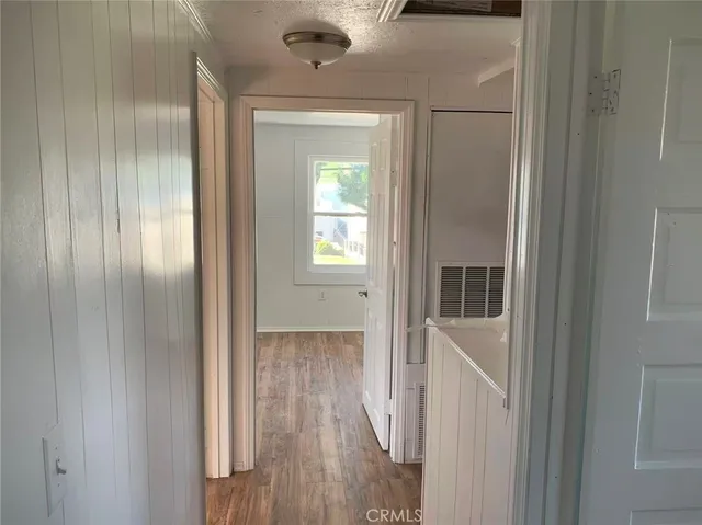 a view of a hallway with wooden floor and entryway