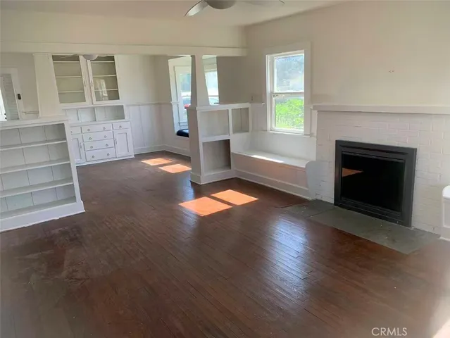 an empty room with windows and fireplace