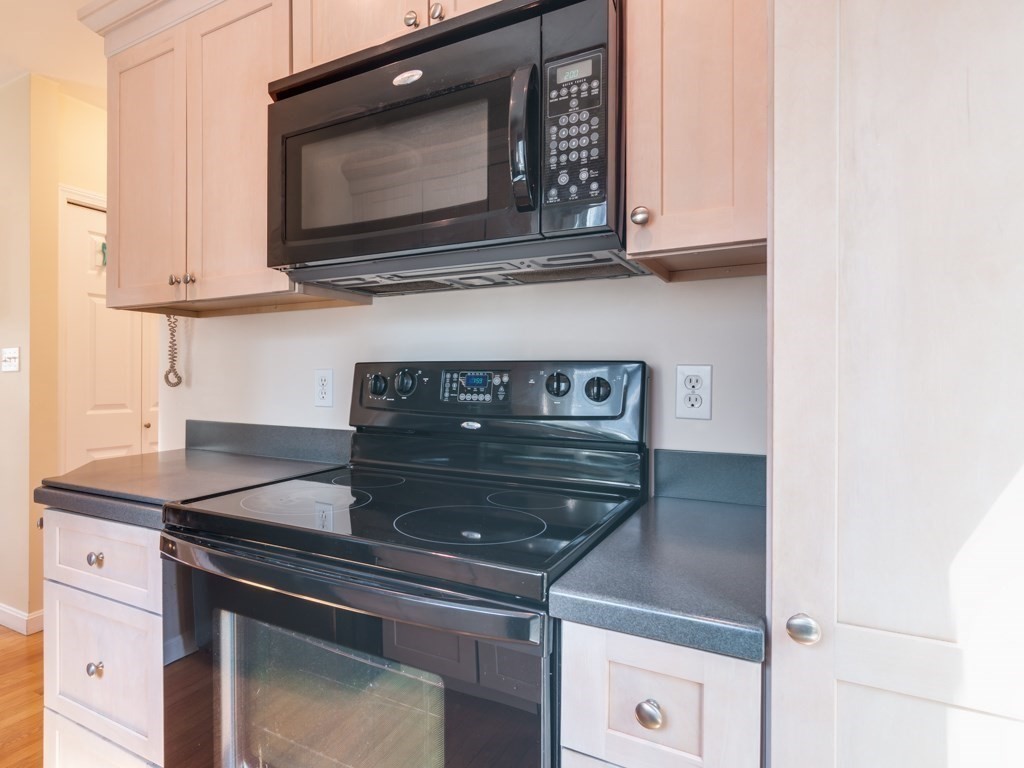 5 White Way Rockport, MA 01966 - Photo 16 of 41 a kitchen with granite countertop white cabinets and black appliances