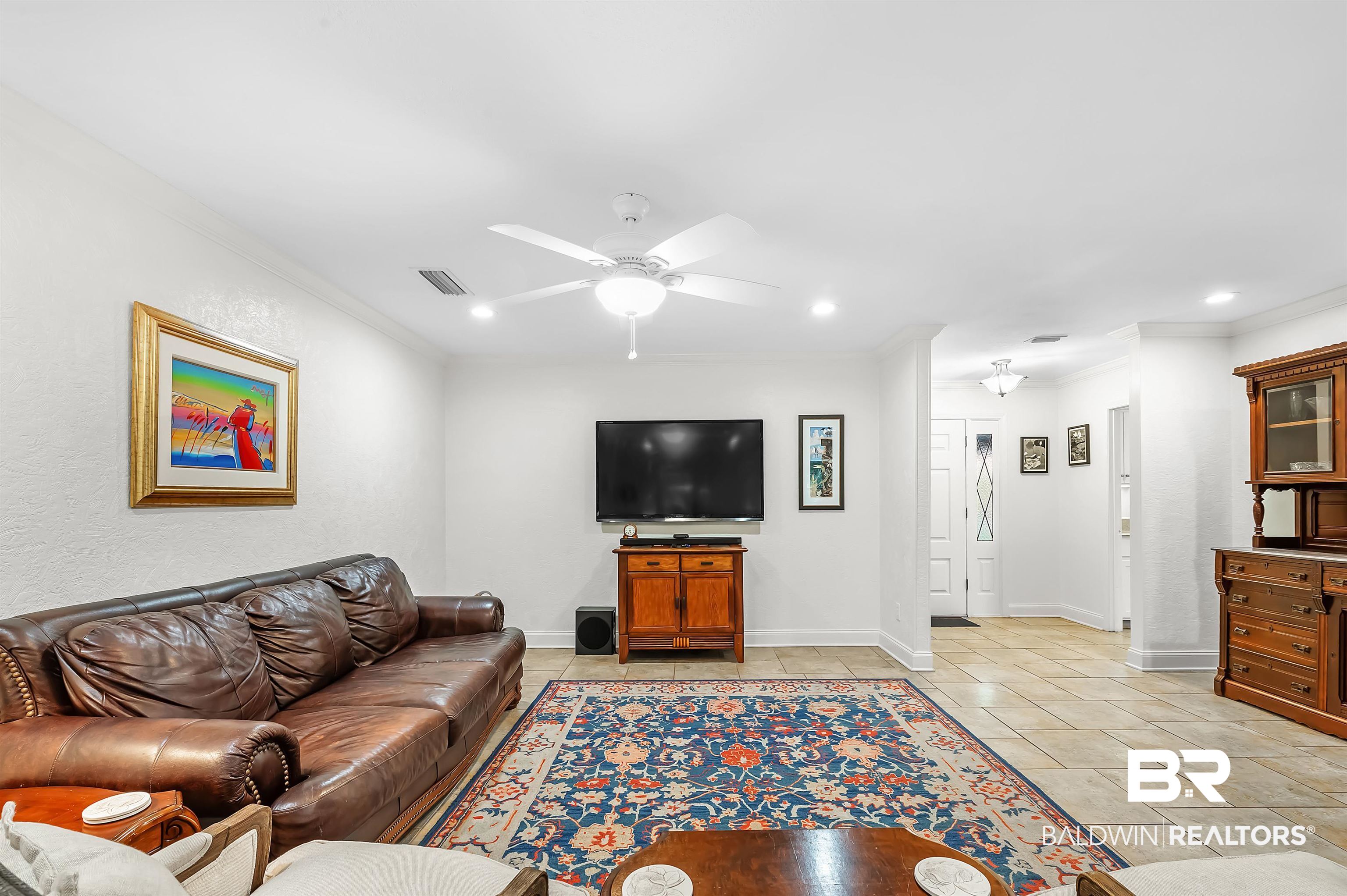 104 James Circle Daphne, AL 36526 - Photo 27 of 62 Living room with ornamental molding, light tile patterned floors, and ceiling fan