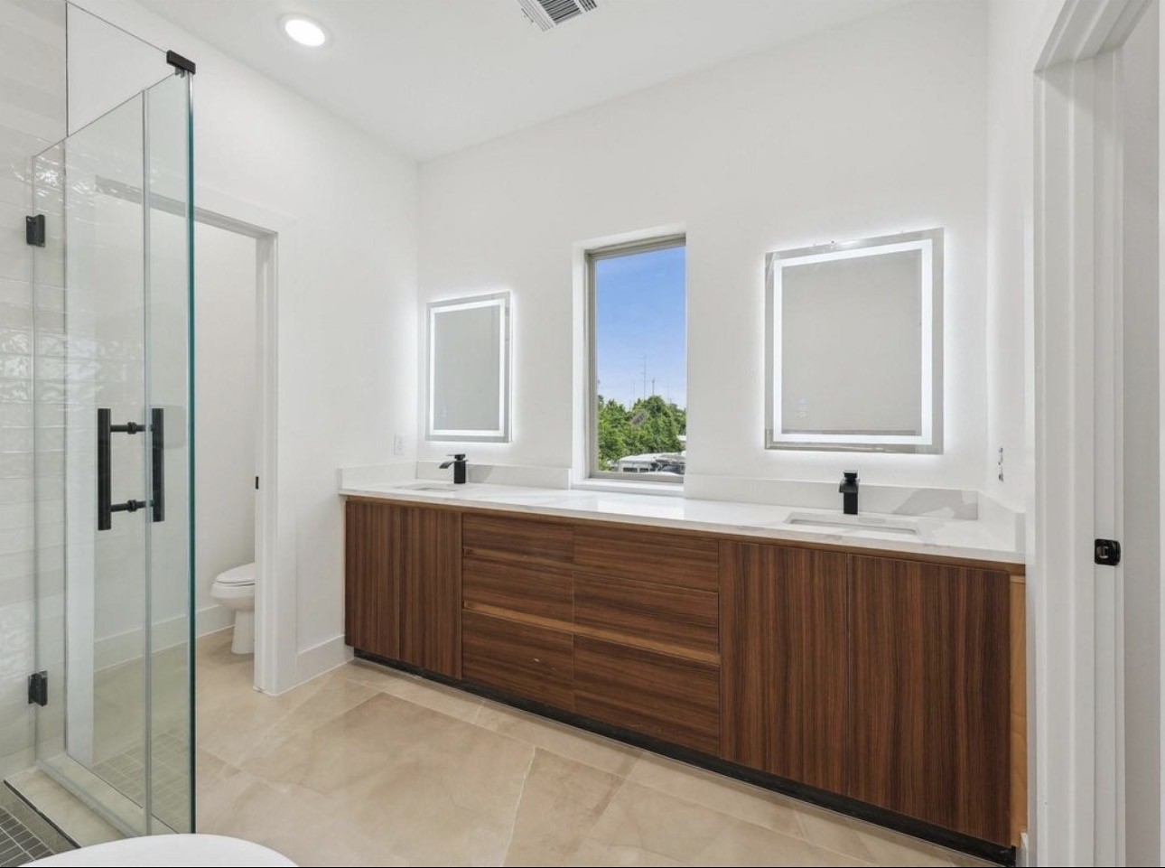 7416 Maxroy Street Houston, TX 77088 - Photo 18 of 35 a bathroom with double vanity sinks and a mirror