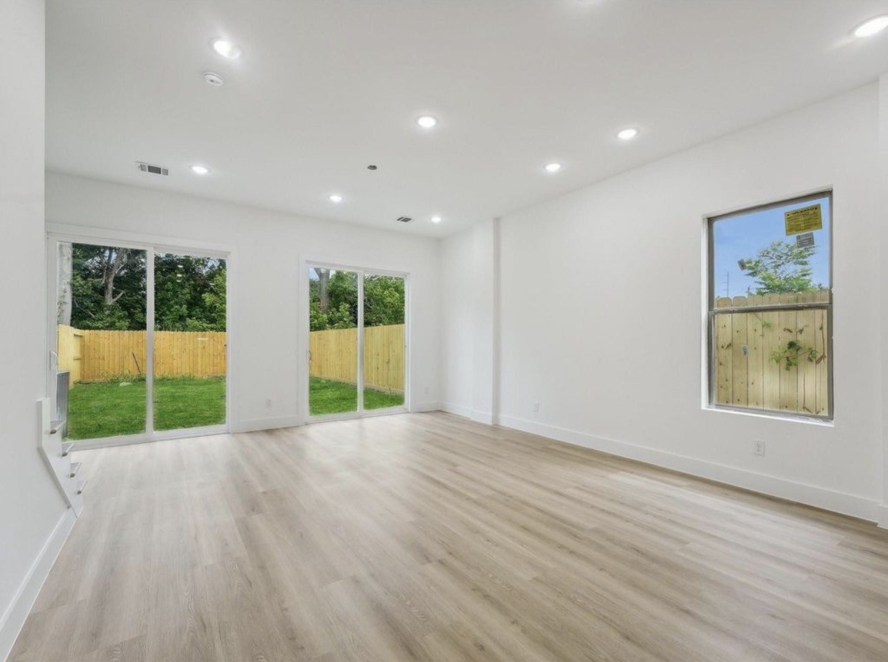7416 Maxroy Street Houston, TX 77088 - Photo 7 of 35 a view of an empty room with wooden floor and a window
