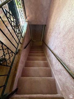 588 North 4500 West West Point, UT 84015 - Photo 25 of 61 Carpeted staircase with an ornamental metal balustrade and a wall-mounted handrail