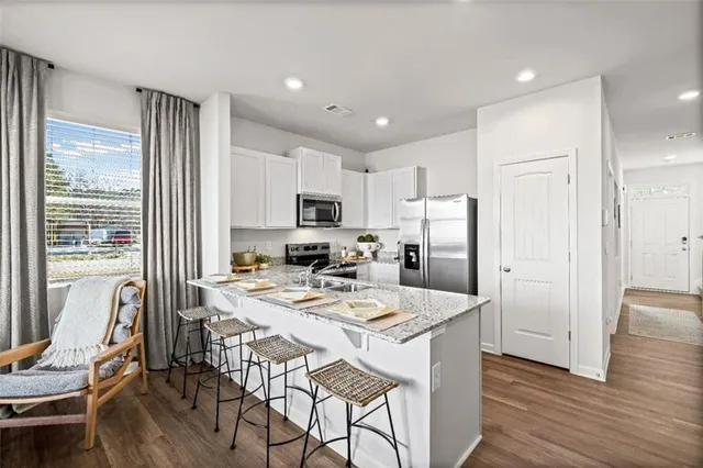 a kitchen with a refrigerator a stove a dining table and chairs