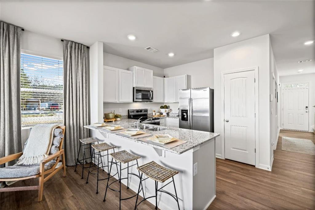 15 Silverbell Lane Rome, GA 30165 - Photo 3 of 26 a kitchen with a refrigerator a stove a dining table and chairs
