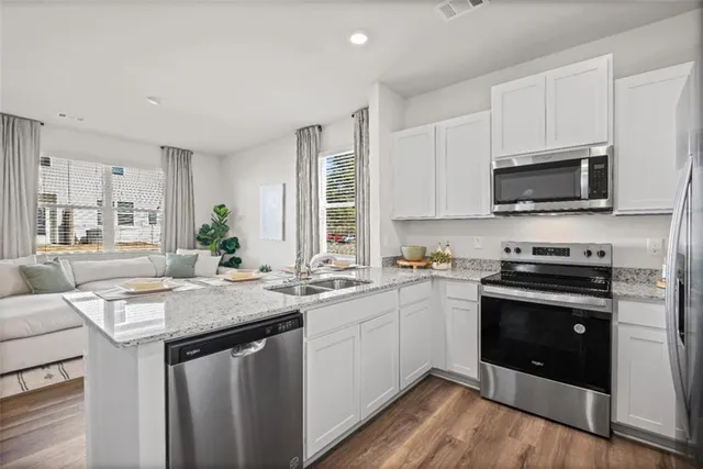 a kitchen with stainless steel appliances granite countertop a sink stove and microwave