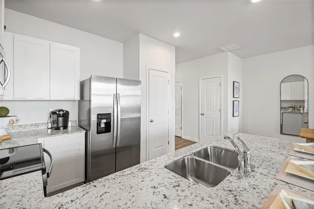 a kitchen with stainless steel appliances granite countertop a sink refrigerator and cabinets