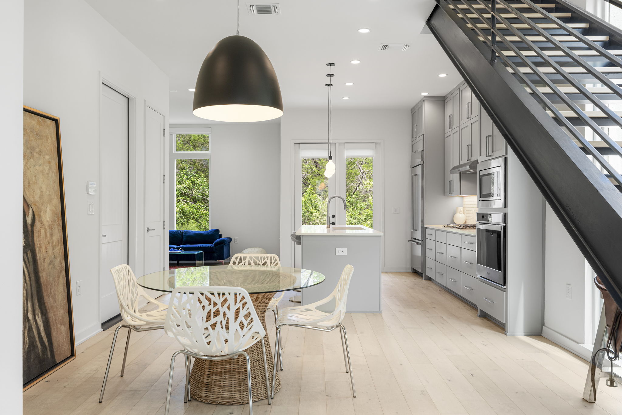 2520 Sutherland Street Austin, TX 78746 - Photo 12 of 26 Blonde wood floors extend throughout this luminous living space, integrating the kitchen and dining areas.