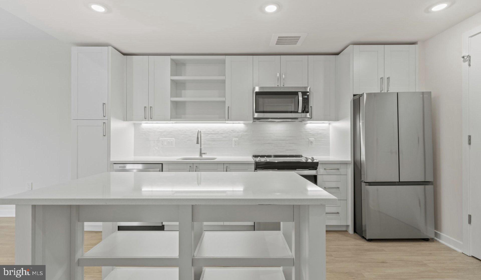 4000 Wisconsin Avenue Northwest, Unit 4K236 Washington, DC 20016 - Photo 28 of 54 a kitchen with kitchen island a counter top space cabinets and stainless steel appliances