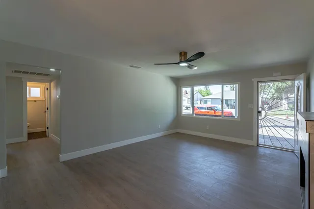 an empty room with windows and fireplace