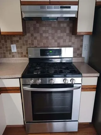 a stove top oven sitting inside of a kitchen