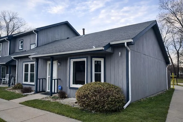 a view of a house with brick walls and a yard with plants