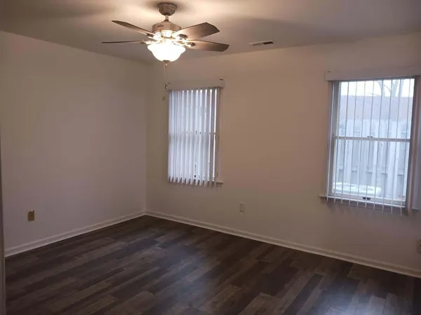 a view of a room with wooden floor and windows