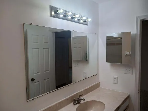 a bathroom with a sink vanity and mirror