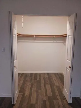 a view of walk in closet with wooden floor