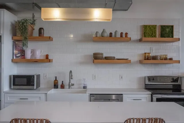 a kitchen with stainless steel appliances granite countertop a sink a stove and a microwave