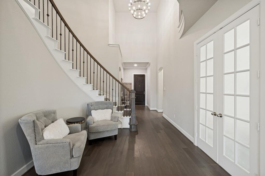 2721 Old Shire Path Road Prosper, TX 75078 - Photo 3 of 39 Two-story foyer featuring a curved staircase with wrought iron spindles, dark wood-finish flooring, high ceilings, and double French doors with frosted glass