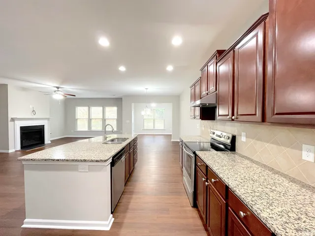 a living room with furniture a fireplace and a chandelier