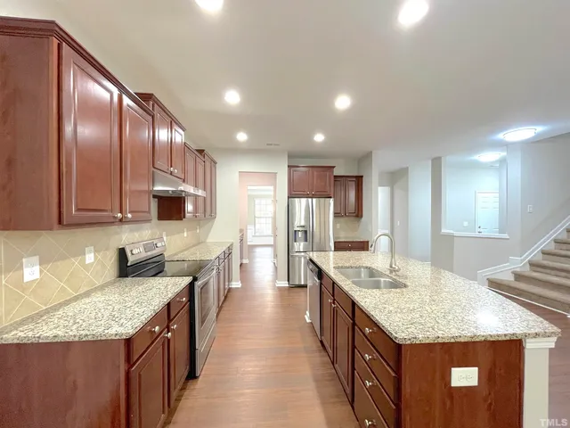a kitchen with granite countertop a sink and cabinets