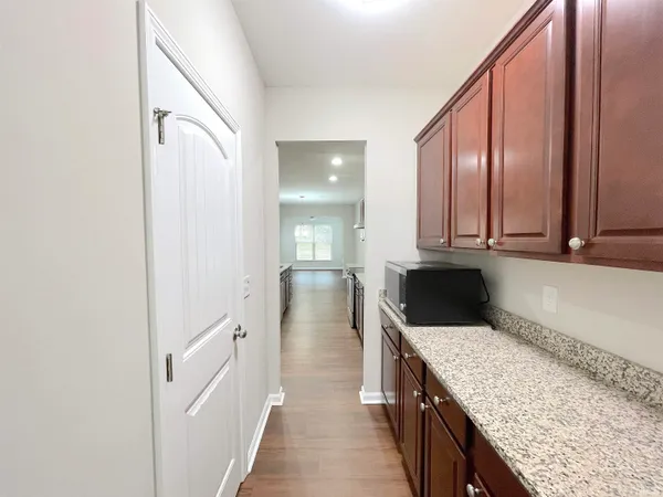 a view of kitchen with sink a microwave and wooden floor