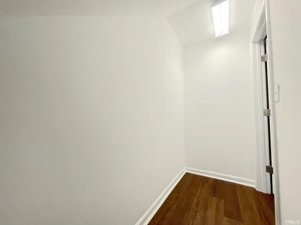 a hallway with a sink and a stove with wooden floor
