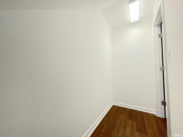 a hallway with a sink and a stove with wooden floor