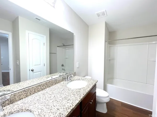 a view of a room with wooden floor and a ceiling fan