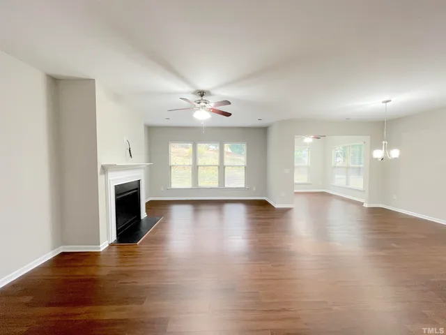 a kitchen with stainless steel appliances granite countertop a refrigerator a sink dishwasher a stove and a wooden floors