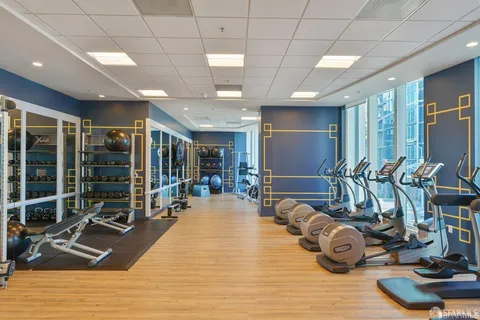 a room with gym equipment and large mirror