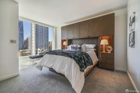 a bedroom with a bed and large windows