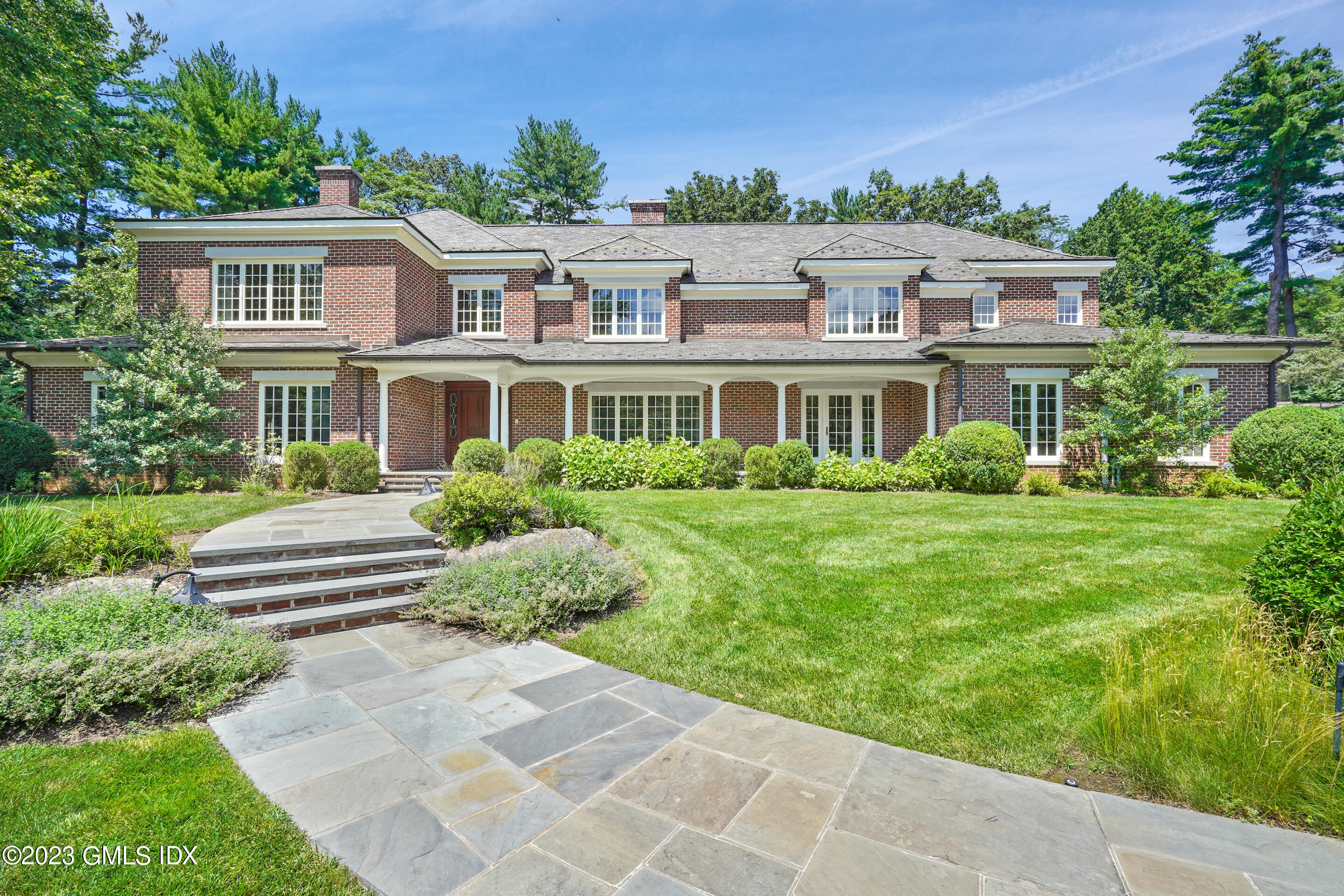 151 Clapboard Ridge Road Greenwich, CT 06831 - Photo 3 of 34 a front view of a house with a garden