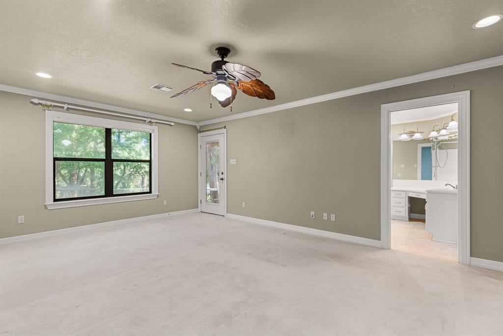 13539 Chapel Road Lorena, TX 76655 - Photo 15 of 37 Spacious room featuring neutral carpeting, a large window, a glass-paned door, a ceiling fan, and recessed lighting