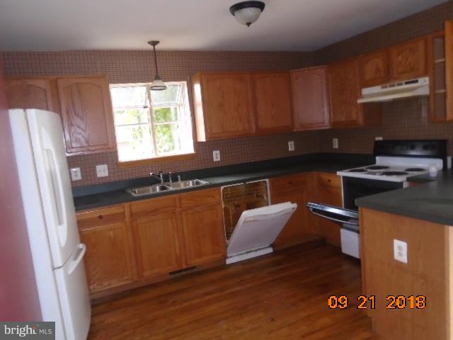 432 Salisbury Road Edgewater, MD 21037 - Photo 3 of 8 a kitchen with stainless steel appliances granite countertop a refrigerator a sink dishwasher a stove and white countertops with wooden floor