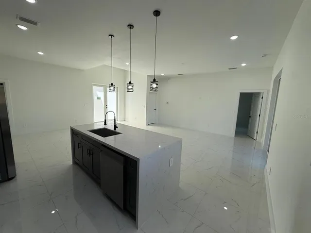 a kitchen with stainless steel appliances granite countertop a sink a refrigerator and a stove