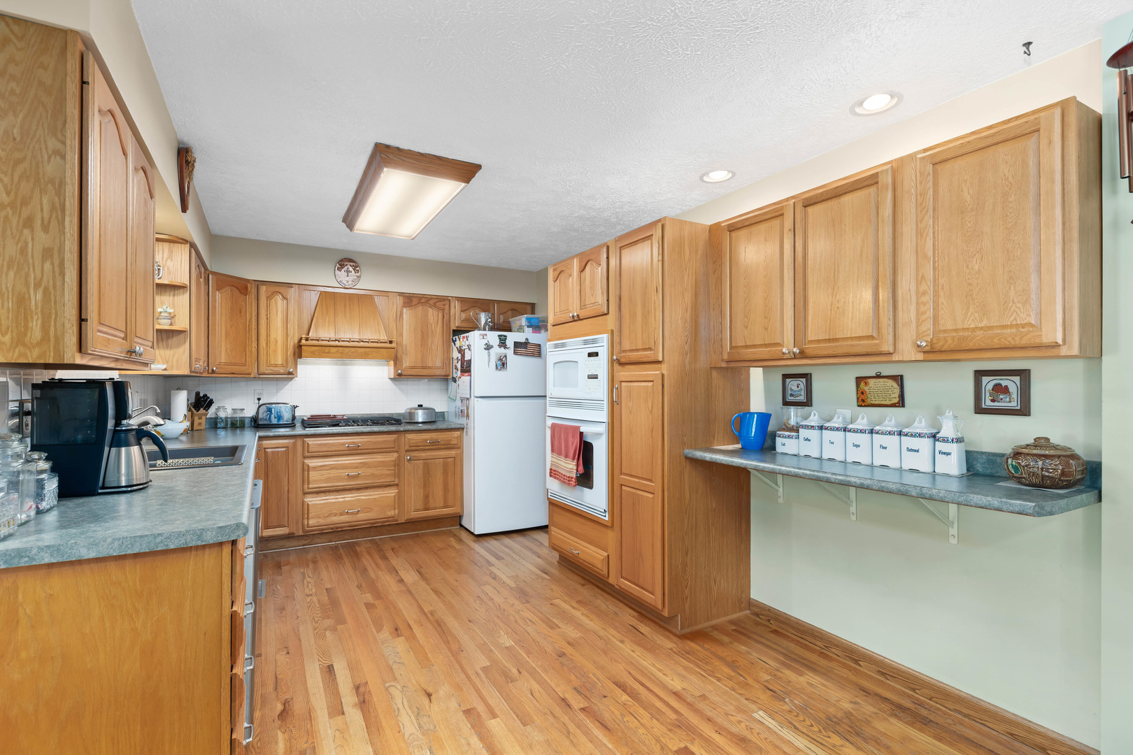 26310 South McKinley Woods Road Channahon, IL 60410 - Photo 10 of 49 a kitchen with stainless steel appliances wooden floors and wooden cabinets