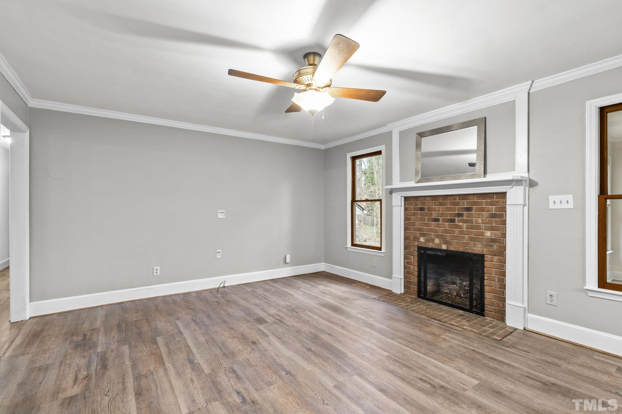 805 Van Thomas Drive Raleigh, NC 27615 - Photo 15 of 38 a view of an empty room with wooden floor fireplace and a window